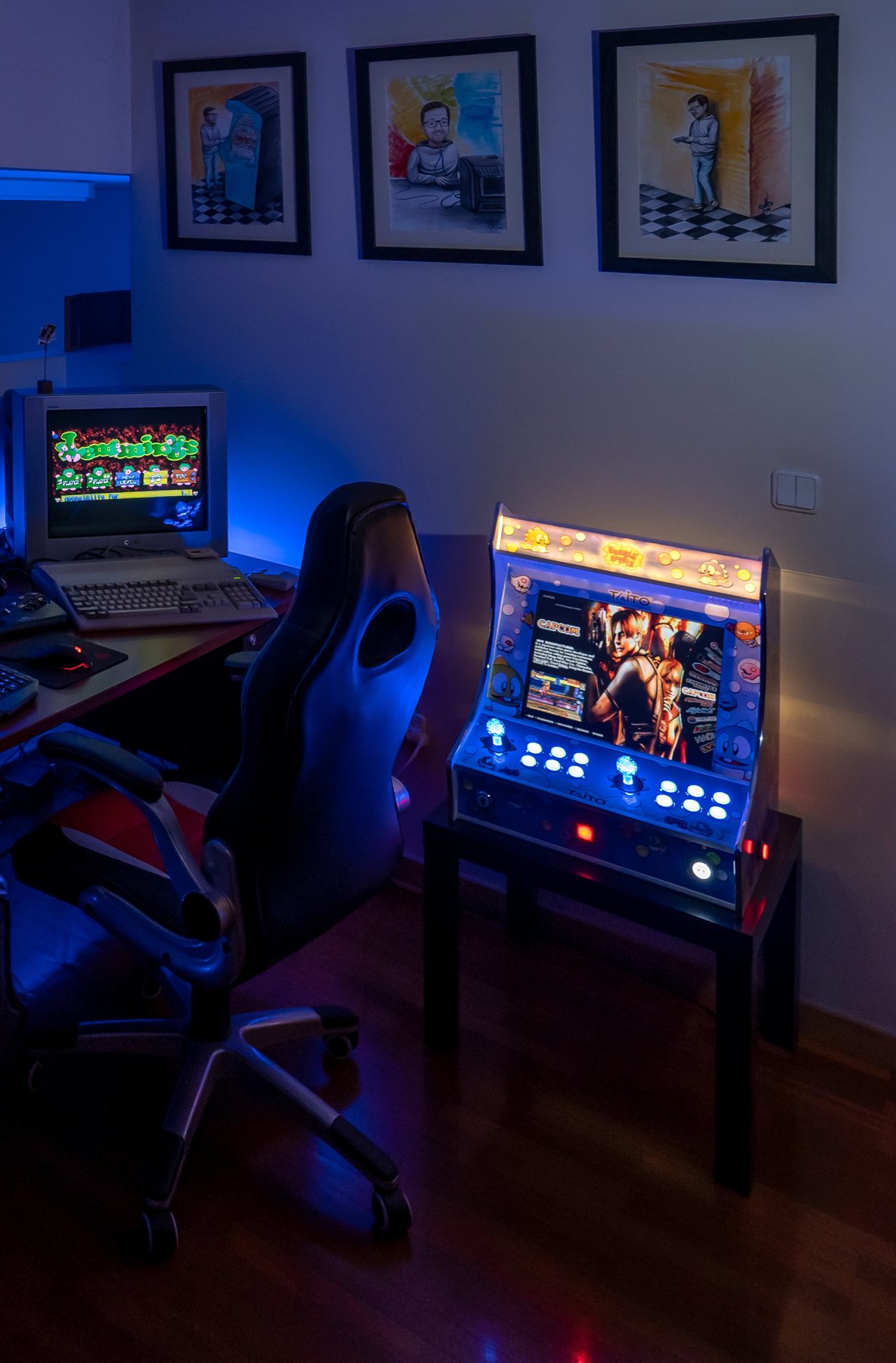 O meu bartop de arcade aceso, ao lado de um computador com monitor de tubo e de três quadros desenhados na parede